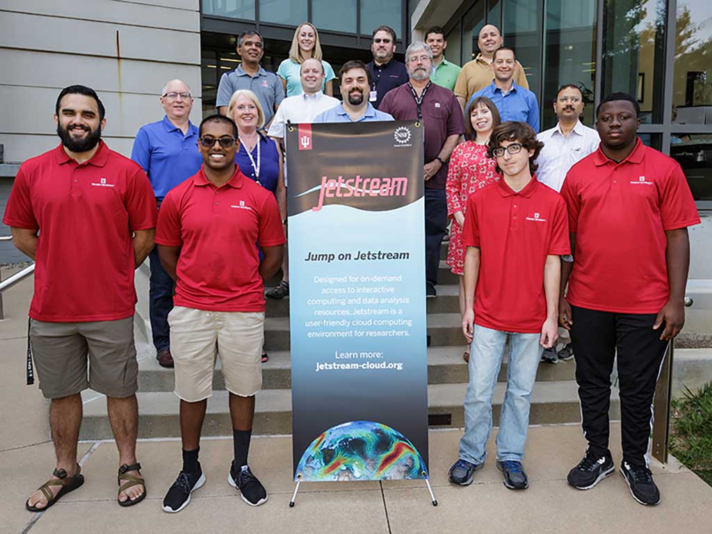 A group of Jetstream REU students and Jetstream staff stand outside the Cyberinfrastructure Building at IU Bloomington.